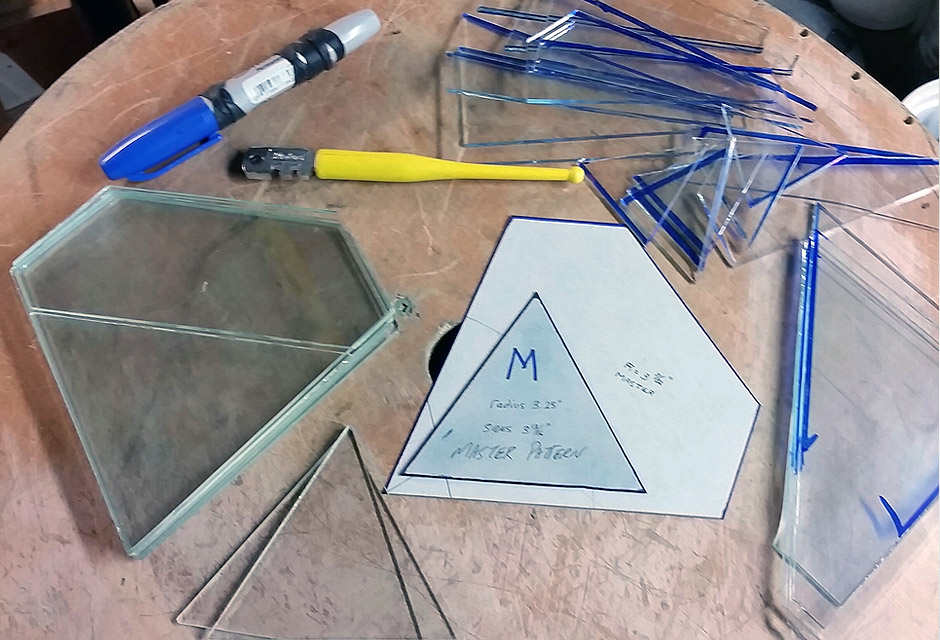 cutting glass pieces out with glass cutter and paper patterns